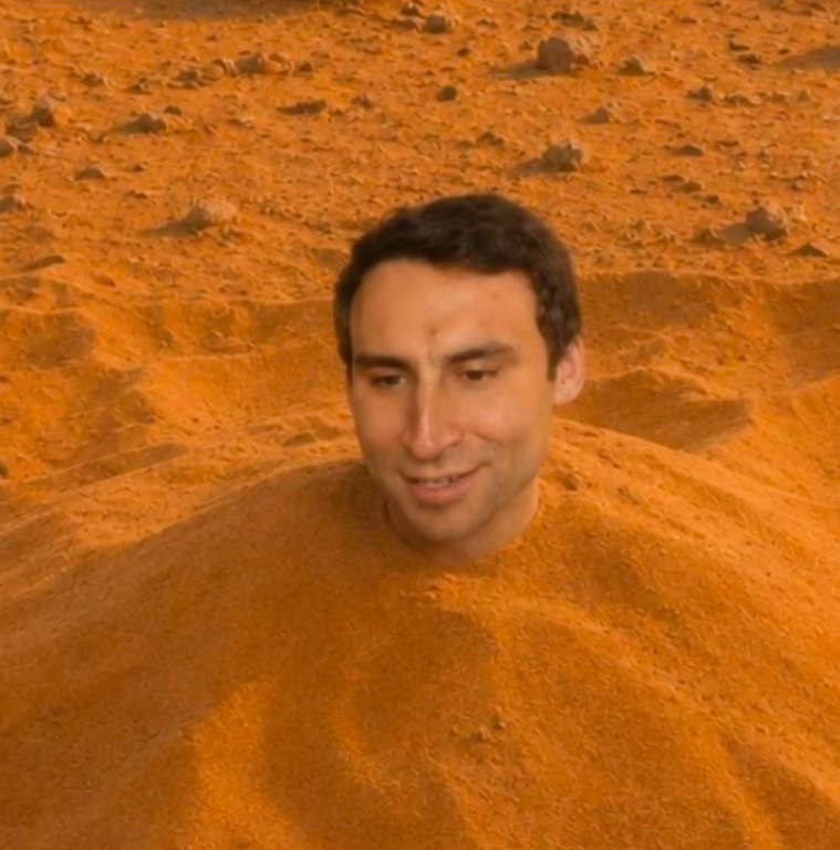Character buried to the neck in an orange desert
